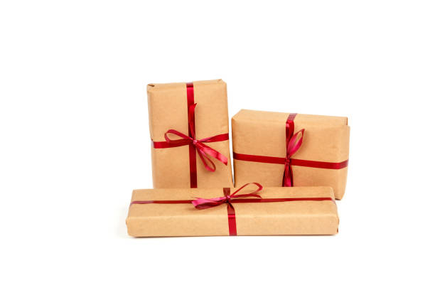 istock Gift Boxes in Craft Wrapping Paper with Red Ribbons isolated 1190553390