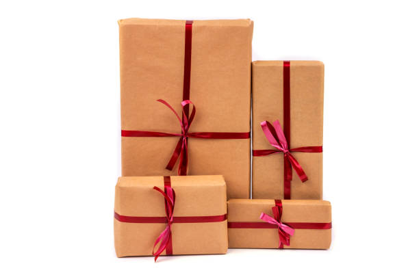 istock Gift Boxes in Craft Wrapping Paper with Red Ribbons isolated 1190554010