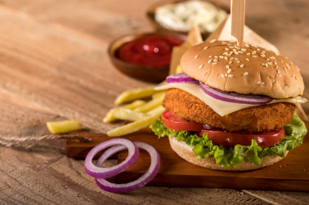 istock Fresh burger with chips and sauces on wooden background 1190554058