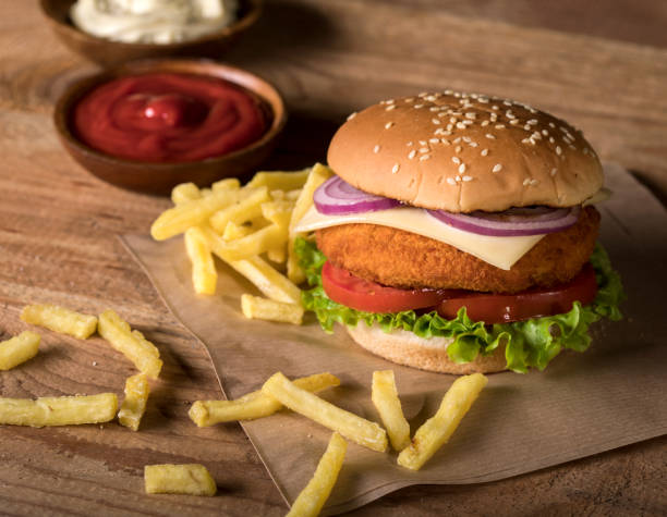 istock Fresh burger with chips and sauces on wooden background 1190554071