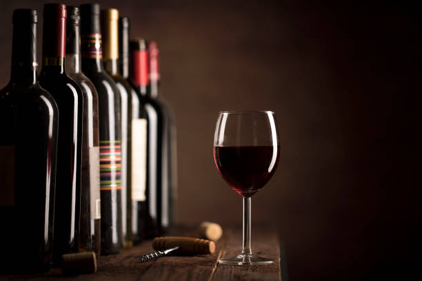 istock Red Wine in glass and bottles on a dark background with copy space 1190554483