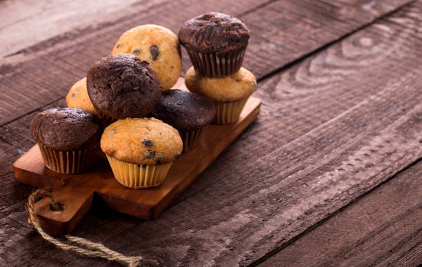 istock Assorted fresh delicious muffins on wooden background 1190554728