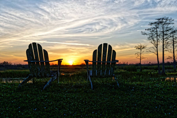 istock Louisiana sunset swamp and chairs 1190557519