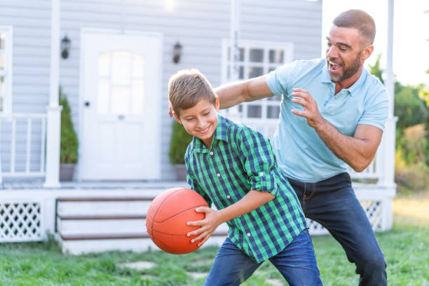istock Father And Son Playing Basketball in front of front yard 1190560729