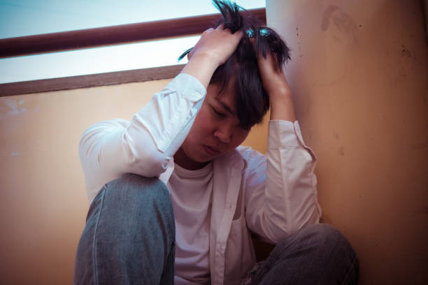 istock Depressed man sitting head in hands in building. with low light environment, dramatic concept, concept of Major depressive disorder, unemployed, sadness, depressed and human problems, 1190562835