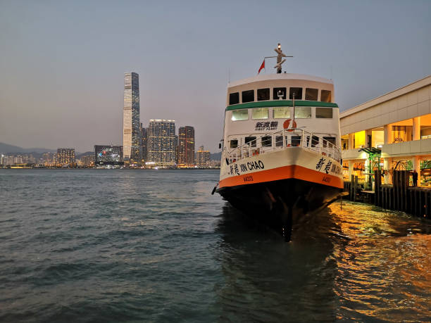 Ferry at Central piers in Hong Kong Ferry approaching at pier in Hong Kong Central. In the background, International Commerce Center skyscraper, the tallest building in Hong Kong. international commerce center stock pictures, royalty-free photos & images