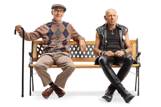 istock Senior man with a cane and a punk man sitting on a bench 1190565214
