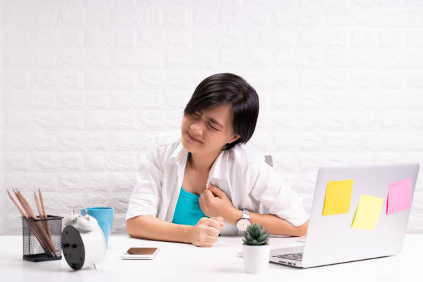 istock Woman has chest pain at office 1190566889