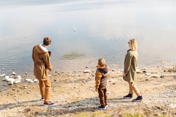 istock father teaching little son throw rocks in water 1190567099