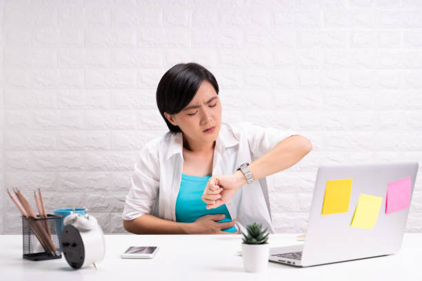 istock Woman has stomachache at office 1190568576