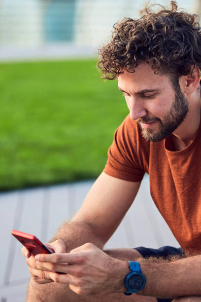 istock Young adult man using modern cellphone in the park. 1190569892