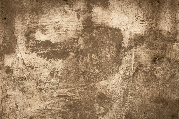 istock Brown shabby concrete wall. Peeling stucco, background. Abstract plaster texture. Ruined facade of a building. Faded paint. 1190570862