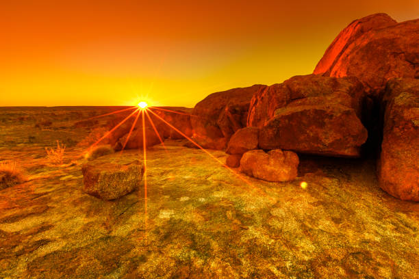 Aerial Devils Marbles sunset Vibrant orange and red colors of sunset sky over giant granite boulders at Karlu Karlu or Devils Marbles in Northern Territory, Australia. Aerial view with sunrays. northern territory australia stock pictures, royalty-free photos & images