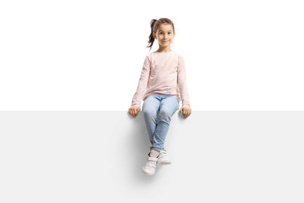 Girl sitting on a blank banner Girl sitting on a blank banner isolated on white background girl sitting stock pictures, royalty-free photos & images