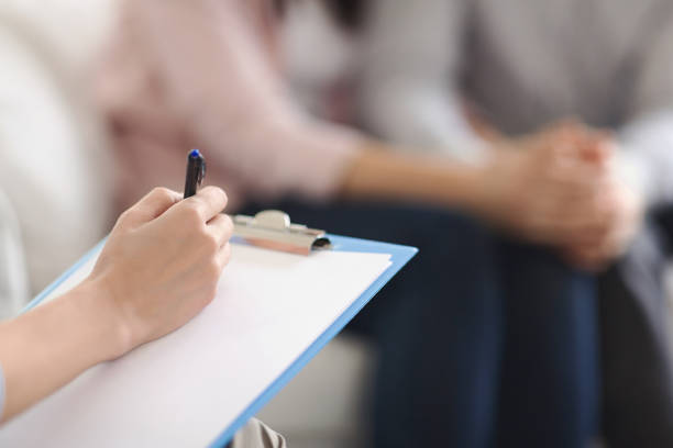 istock Psychologist writing in blank notepad at family counseling session 1190572401