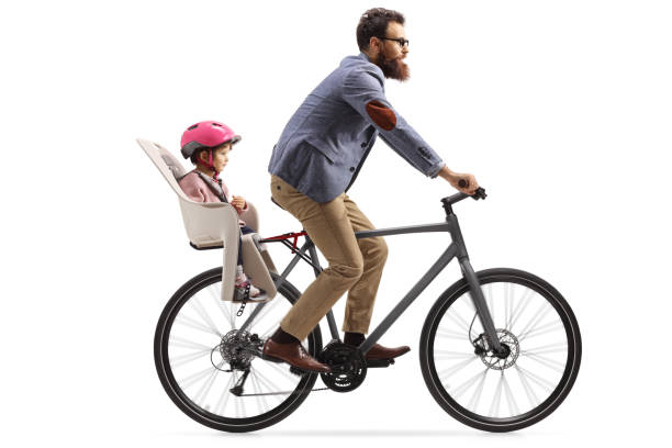 man riding a bicycle with a little girl with a helmet inside a childs seat - helmet bicycle little girls child imagens e fotografias de stock