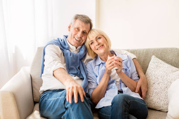 istock Happy mature couple sitting on sofa and embracing 1190573818