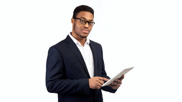 istock Black guy in suit standing with tablet 1190575906