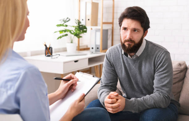 istock Stressed young man talking to psychologist at therapy 1190577193