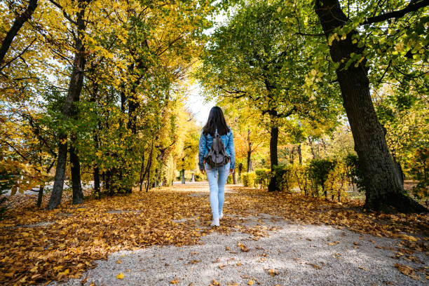 Young cute Caucasian woman walking in a park in Vienna. Autumn time.