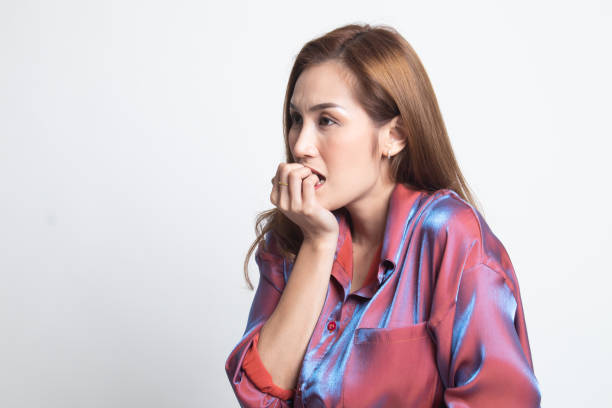 istock Unsure hesitant nervous young asian  woman biting her fingernails. 1190577600