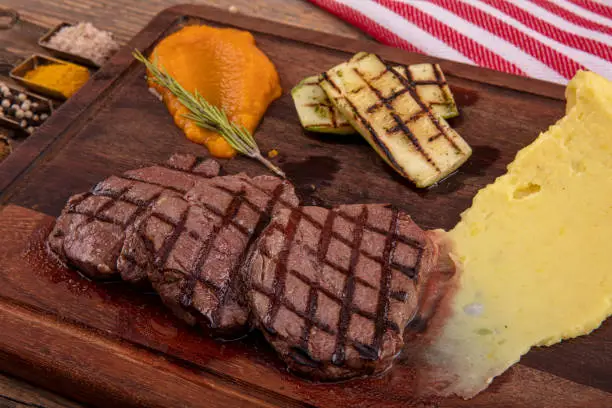 Delicious sliced beef tenderloin on table, closeup. Sirloin steak.