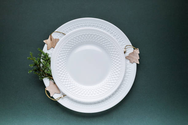istock Elegant Christmas plate setting on a dark green background. Top view 1190578621