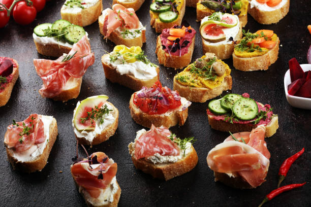istock Assorted bruschetta with various toppings. Appetizing bruschetta or brie crostini. Variety of small sandwiches. Mix bruschetta on table 1190578677