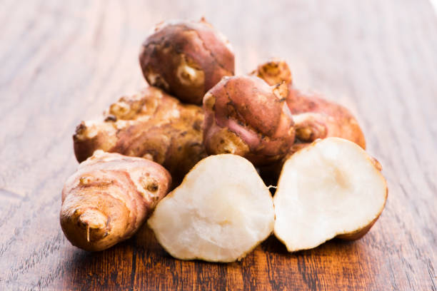 istock Raw Whole ans sliced Jerusalem artichokes on a cutting board 1190580449