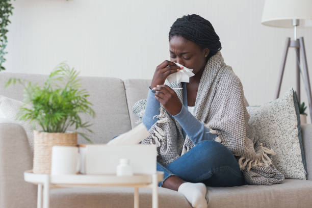 istock Black girl having flu, blowing nose and checking body temperature 1190581128