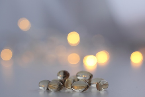 Closeup of vitamin D capsules with bokeh in the background. Supplement for autumn and winter.