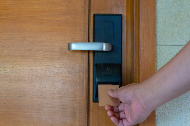 istock Man's hand inserts card to open electronic lock in hotel door. 1190581582