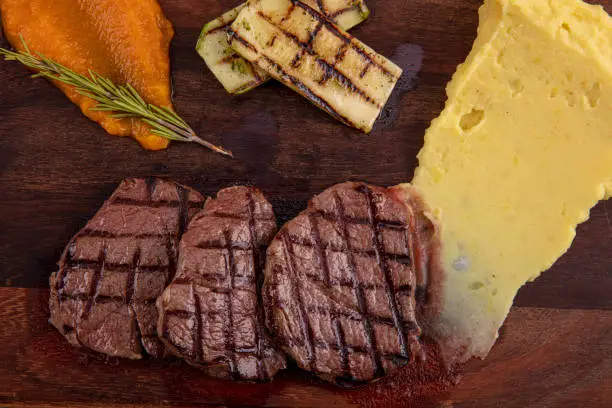 Delicious sliced beef tenderloin on table, closeup. Sirloin steak.
