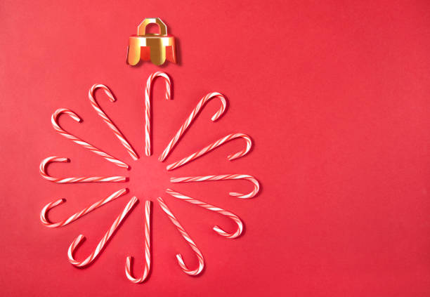 Candy canes forming a Christmas ornament on red background with copy space