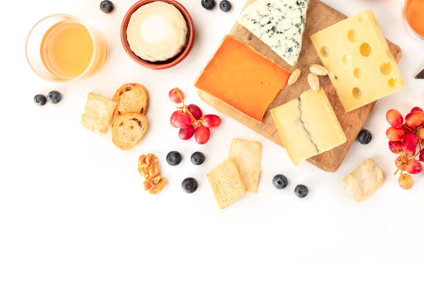istock Cheese, a flat lay overhead shot on a white background with copy space. Blue cheese, Leicester, Emmental, and others sorts with wine, fruits, nuts, and a place for text 1190585977