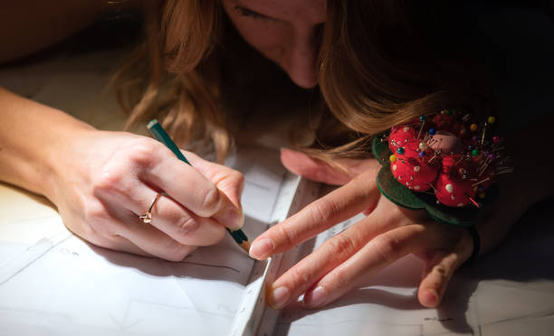 istock Woman fashion designer created sewing pattern close up. Dark lit image. 1190586021