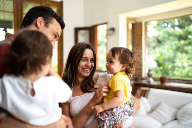 istock Family with two twins playing in the house 1190586949