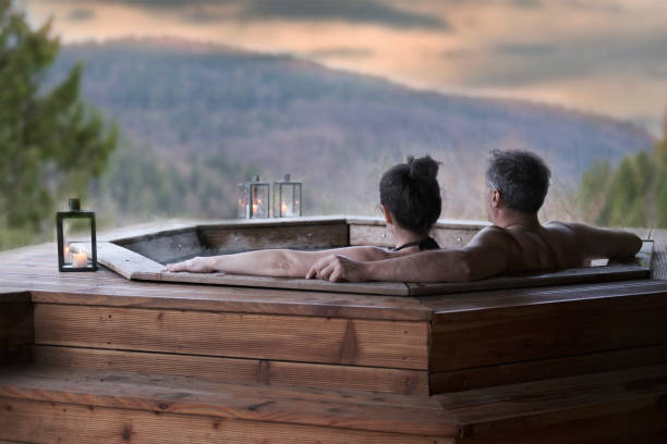 The young couple in an open-air bath with a view of the mountains. stock photo