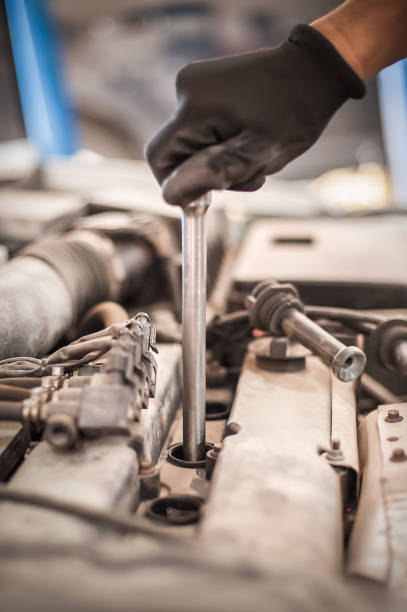 istock Auto mechanic repairer changing spark plugs on the car 1190588349