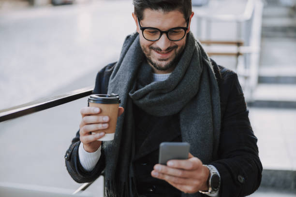 istock Smiling good-looking man in eyeglasses typing message 1190589145