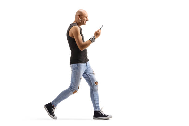 istock Bald male hispter walking and holding a mobile phone 1190589384