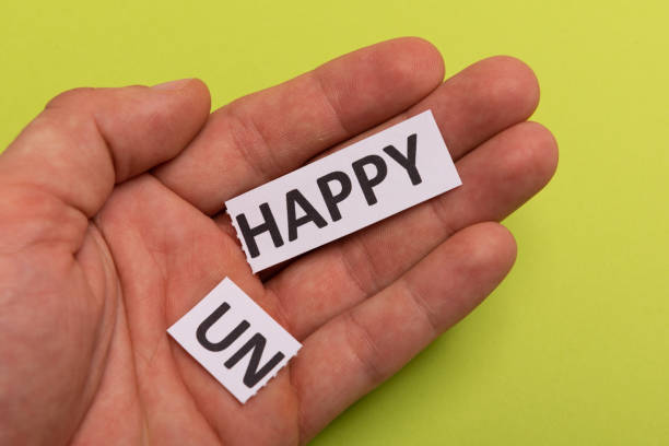 istock man hand holding card with text unhappy, cutting word 'un' so it written 'happy'. Copy space. Lime background. Studio shoot 1190590752
