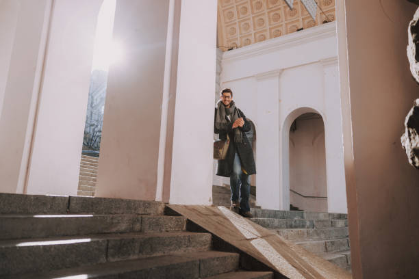 istock Caucasian man in coat standing on stairs 1190591507