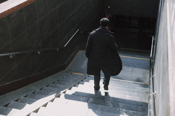 istock Caucasian guy in glasses walking in underground on stairs 1190591684