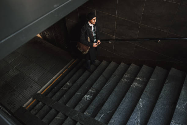 istock Caucasian guy in glasses walking upstairs in underground 1190591702