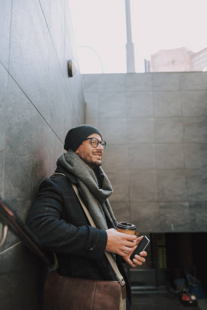 istock Smiling man in warm clothes drinking hot coffee 1190592288