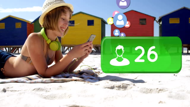 Woman lying on the beach checking her social media account 4k