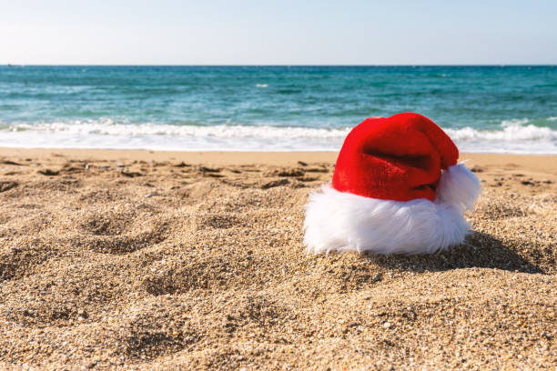 istock Santa Claus hat on sandy beach. Creative Christmas or New Year concept. 1190597703