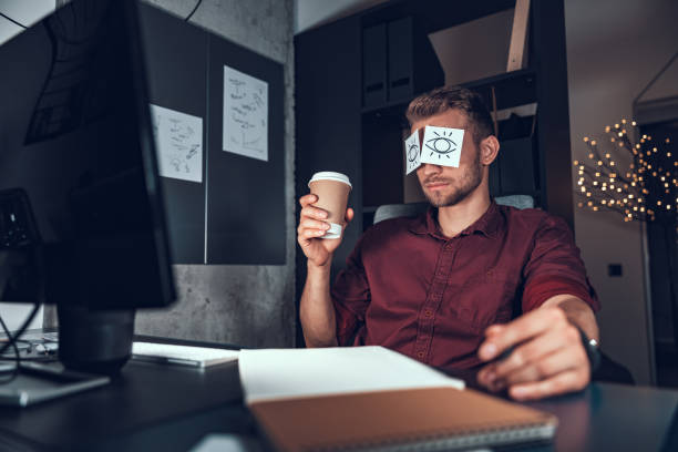 istock Young man with hot drink late at night in the office 1190602033