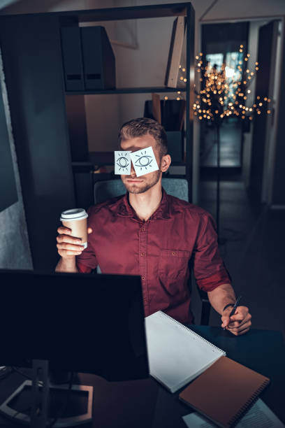 istock Young man is sitting with coffee near computer 1190602036